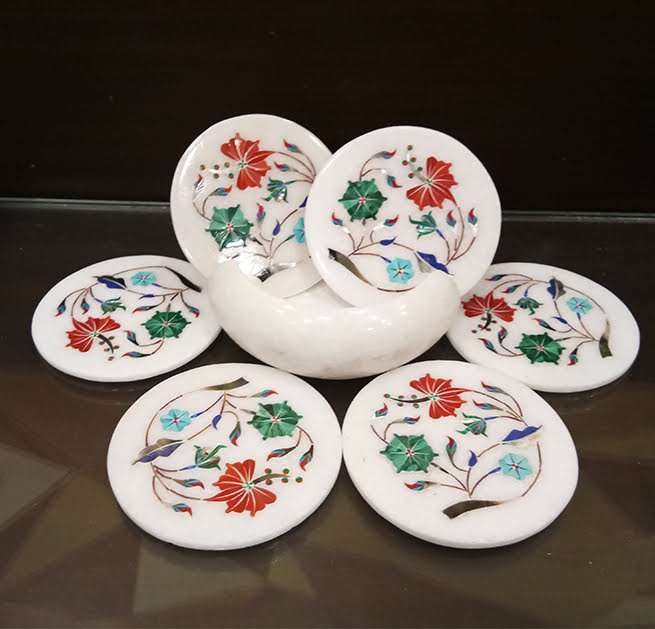 Handcrafted marble coaster with floral stone inlay on wooden table